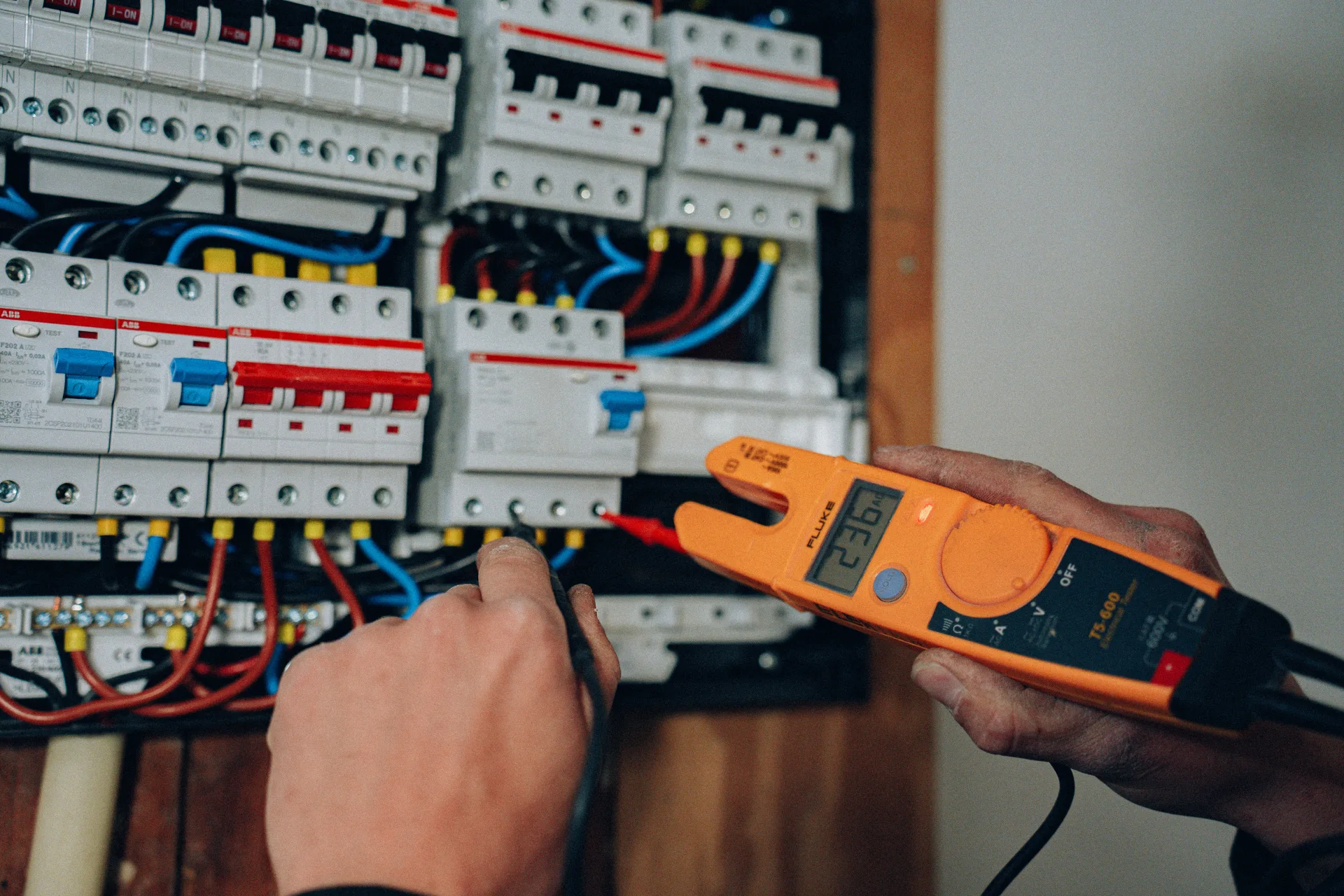 Monteur meet spanning in groepenkast met meetinstrument