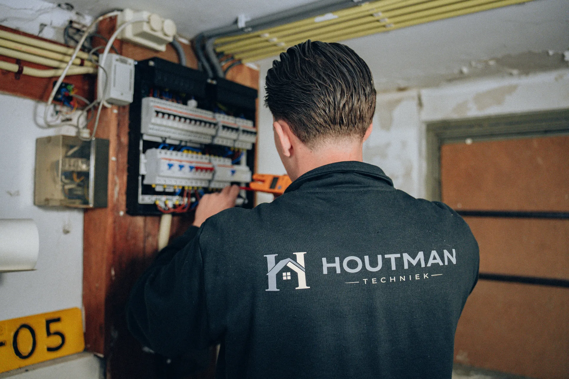 Houtman Techniek monteur werkt met gereedschap aan groepenkast