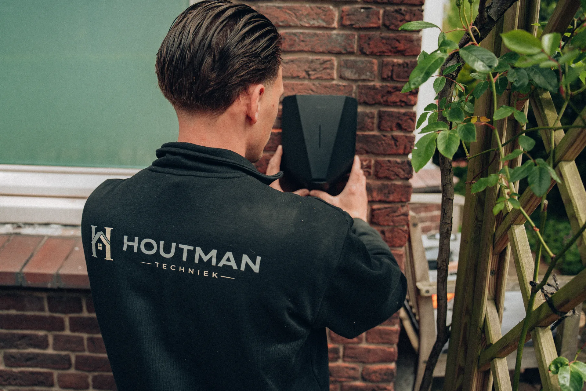 Houtman Techniek monteur installeert laadpaal aan muur