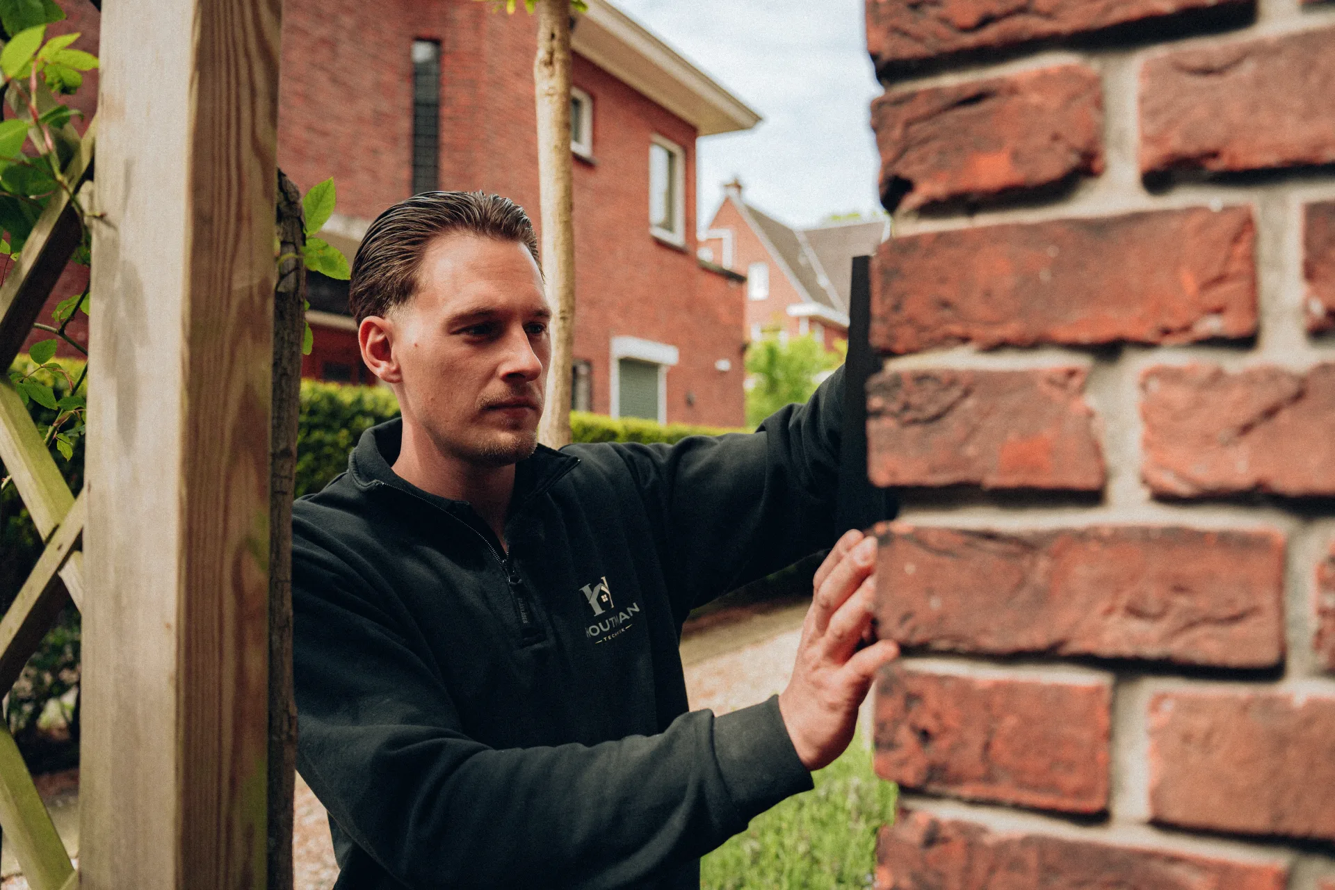 Monteur controleert geplaatste laadpaal aan woningmuur