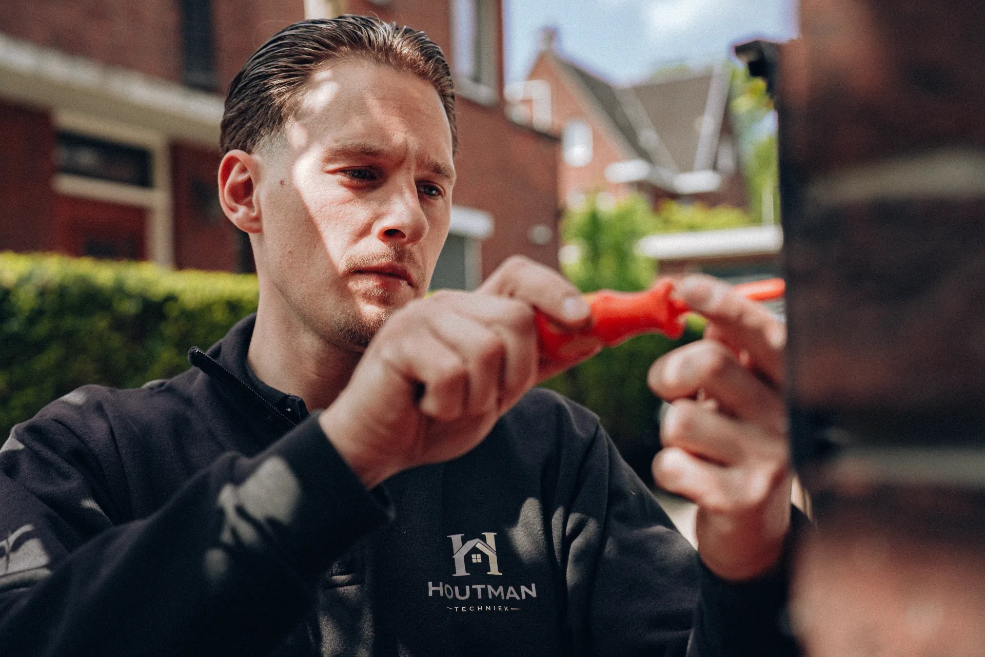 Monteur werkt geconcentreerd met striptang aan installatie