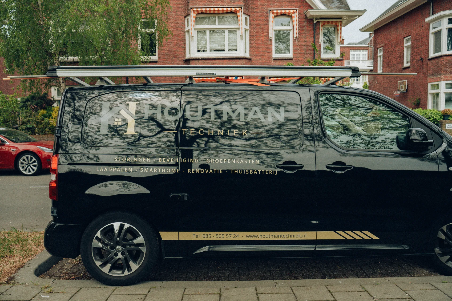 Houtman Techniek werkbus met logo en diensten op de zijkant